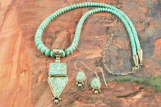 Outstanding Necklace and Earrings Set. Genuine Number 8 Mine Turquoise set in Sterling Silver Pendant. Number 8 mine Necklace featuring Sterling Silver Beads, Cones and Clasp. Plus Beautiful Number 8 Turquoise Earrings. Created by Navajo Artist Lucy Valencia. Signed L. J. by the artist. This is a one of a kind piece. The photo is of the jewelry you will be receiving. The Number 8 mine is located in Eureka County Nevada. Since 1976 there has been no Number 8 Turquoise mined. There is however, an existing stock pile that Mr. Dowell Ward, the last owner of the Number 8 mine, had stocked away for later sorting. The Turquoise is a collector's item--because once the reserve is gone there will be no more material released onto the market. The Gold Mining Company owns the claim to the Number 8 mine and it has been swallowed up by the gold mining operations. This is some of the last Number 8 Turquoise to be had and will be a great addition to your collection.